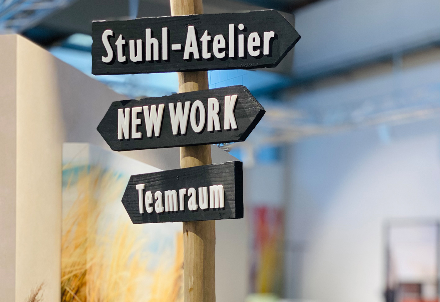 Wir gestalten gemeinsam mit Ihnen Ihre nachhaltigen Bürowelten. Wegweiser in der Ausstellung bei Hela in Mönchengladbach